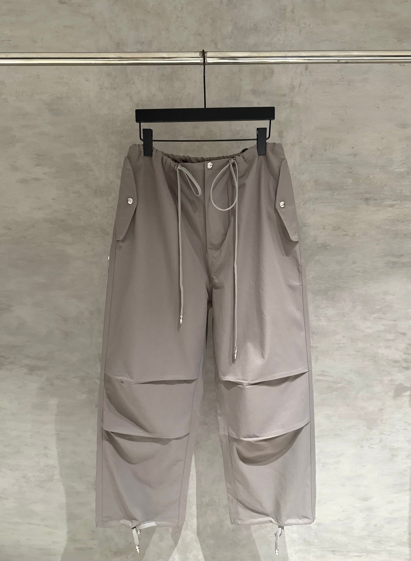 Taupe drawstring cargo pants with zip pockets and side flap details