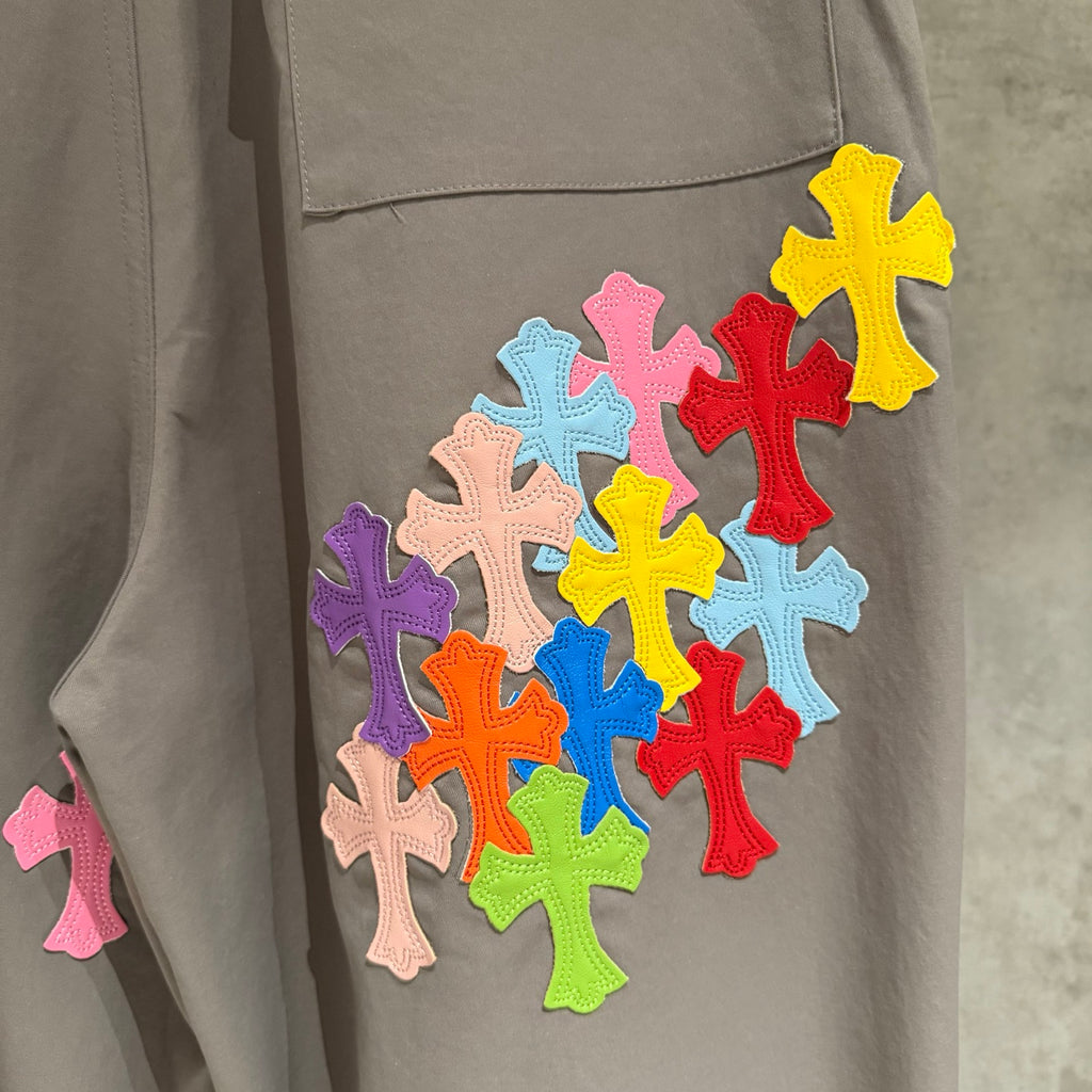Taupe pants with multicolor cross appliqué patchwork near hip