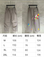 Taupe cargo pants with multicolor cross patches; size chart shows waist and inseam (cm)