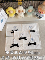 Stack of white Prada gift bags with black ribbon bows and small logo marks