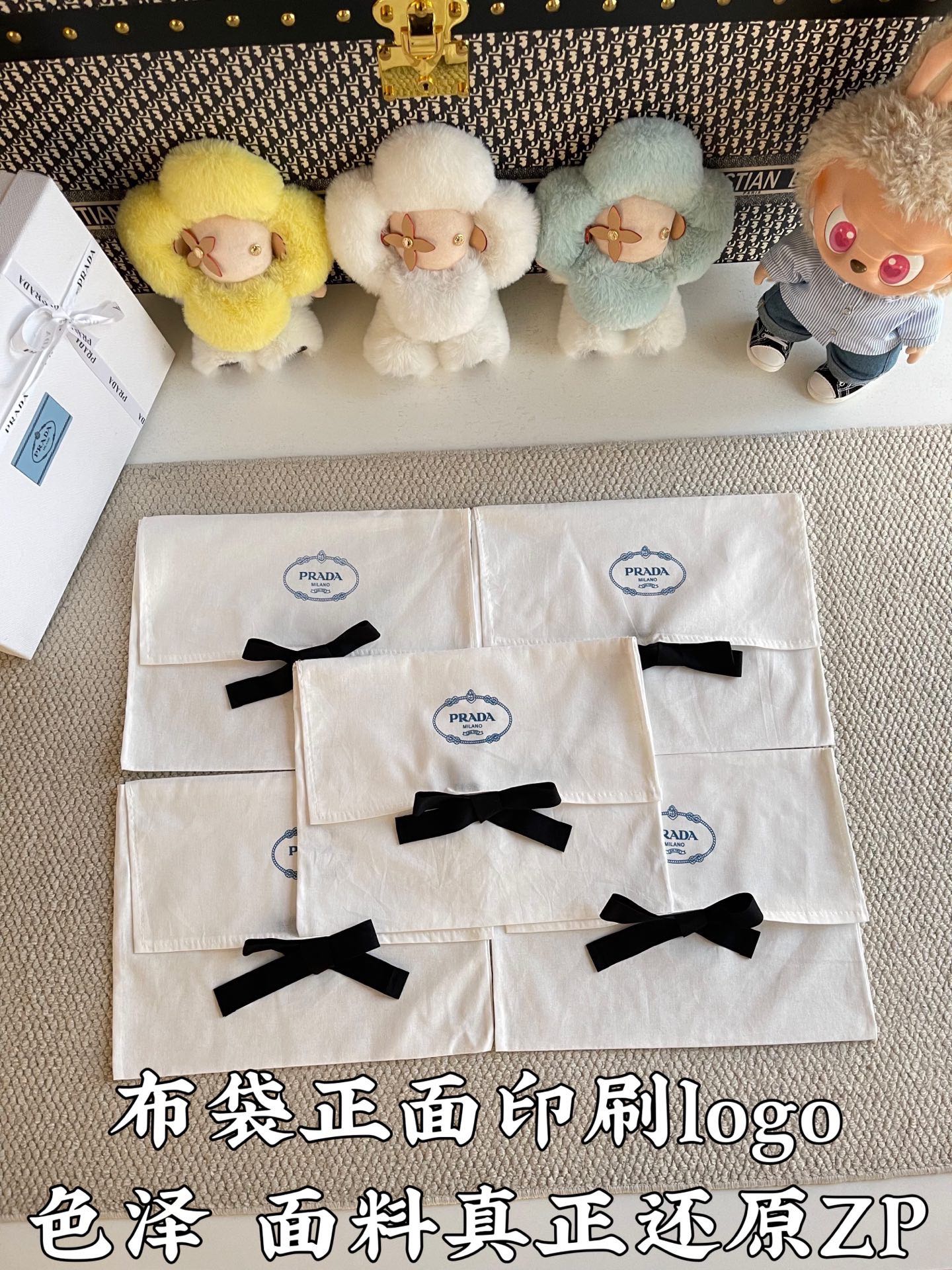 Stack of white Prada gift bags with black ribbon bows and small logo marks