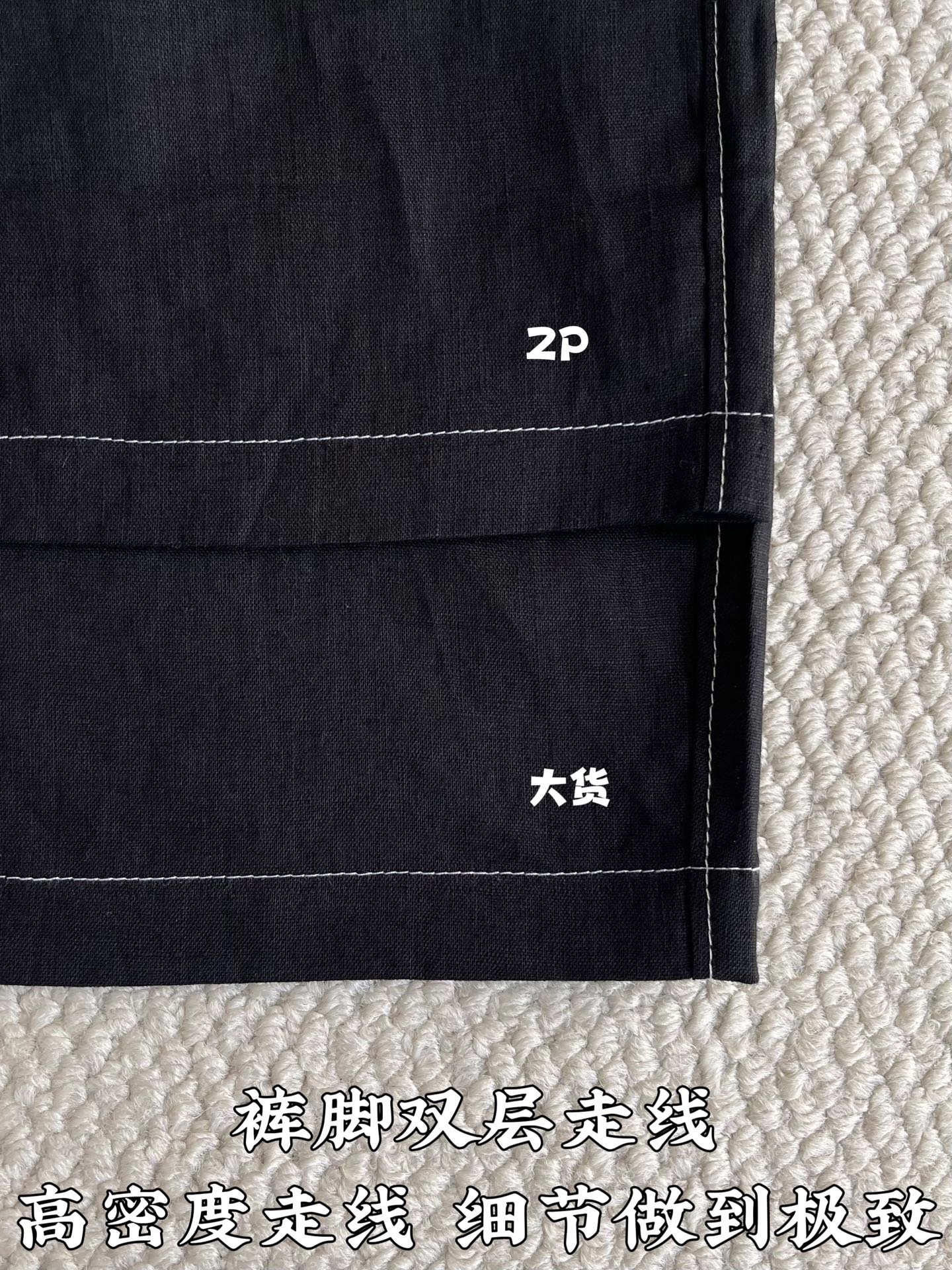 Black shorts side hem close-up with stacked seams and logo marking near pocket