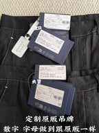 Black shorts with waistband and belt loops; multiple product tags clipped at the front