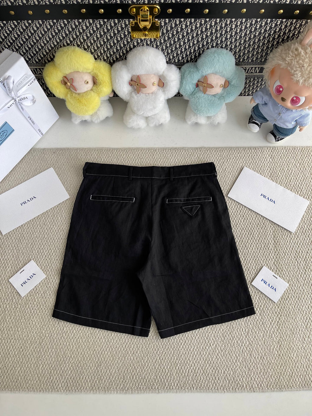 Prada black shorts-style pants with belt loops and front pockets, angled view