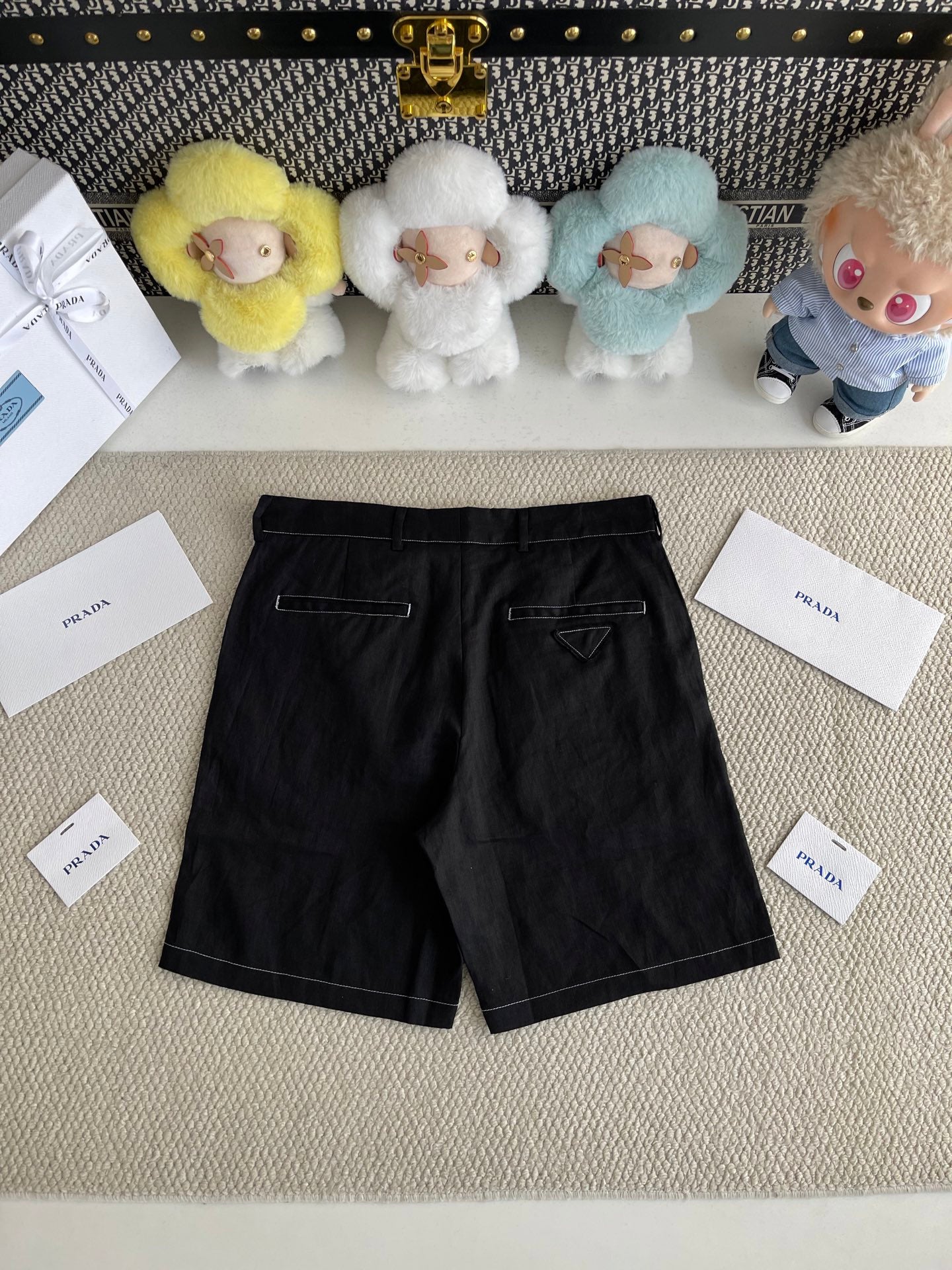 Prada black shorts-style pants with belt loops and front pockets, angled view