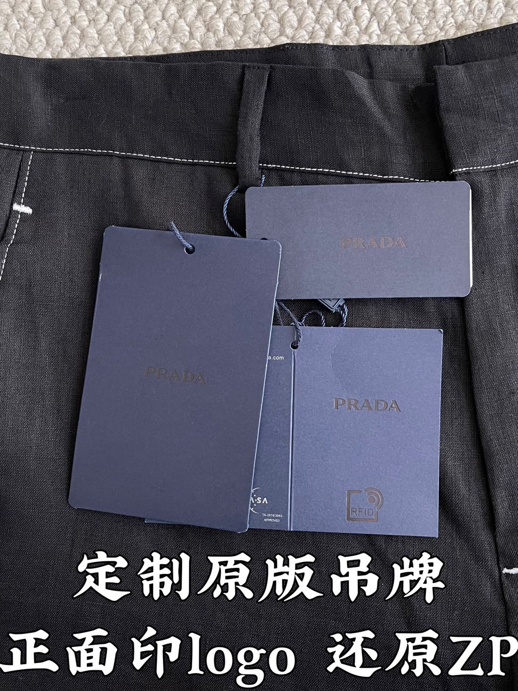 Prada pants in dark fabric with hanging product tags and labels