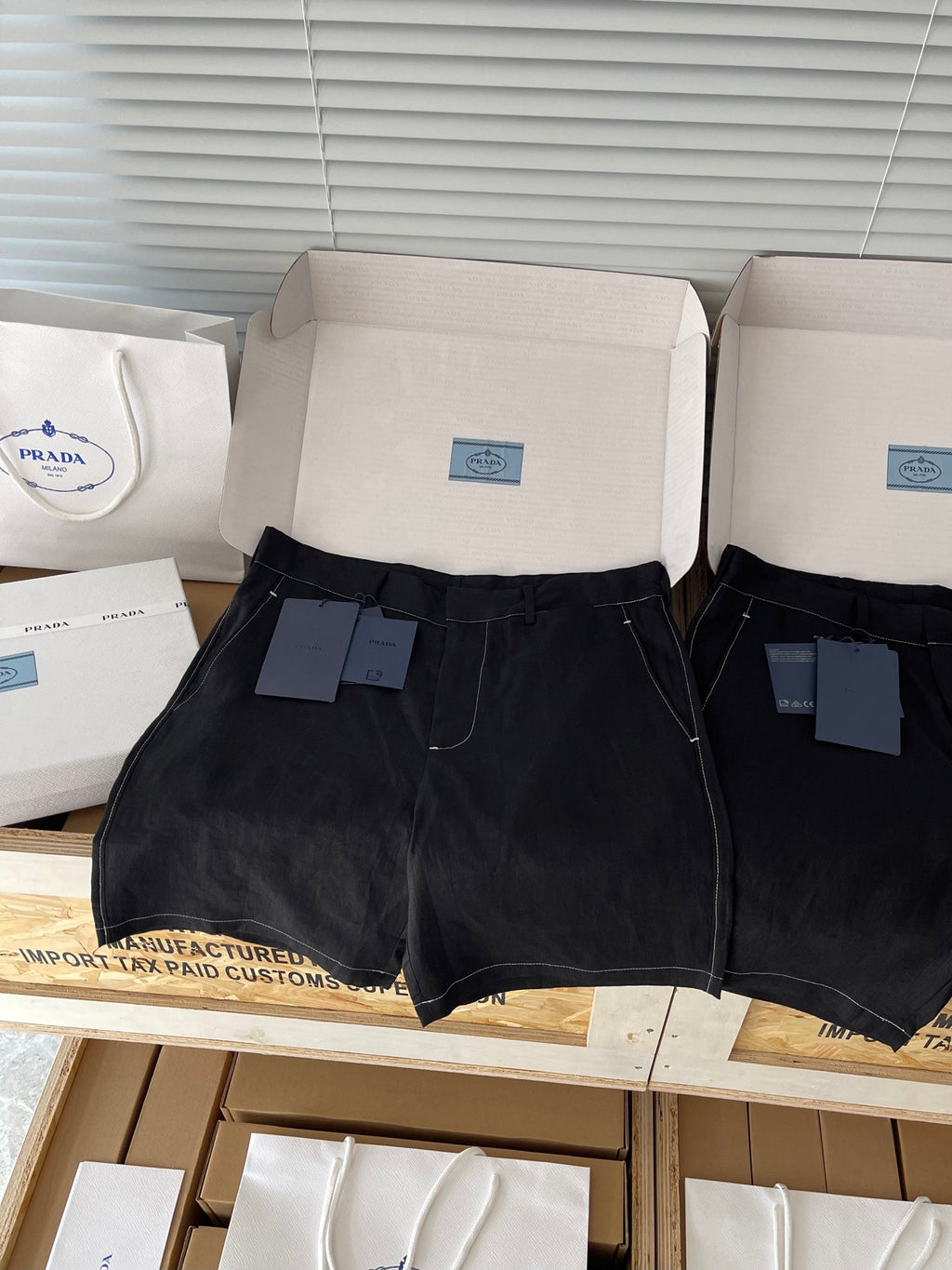 Prada black shorts front view with zip fly, belt loops, small branded tag