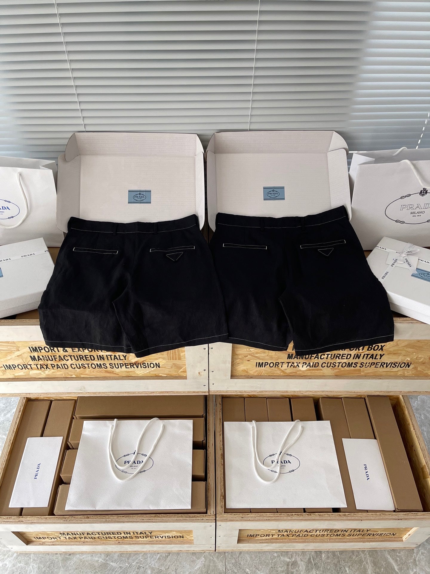 Prada black shorts in boxes, front view with zip fly and belt loops