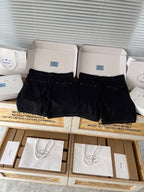 Prada black shorts in box, front view with zip fly, belt loops, buttoned pockets
