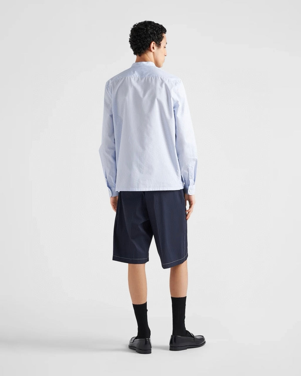 Navy Prada shorts from behind, knee-length hem and front-to-back seams
