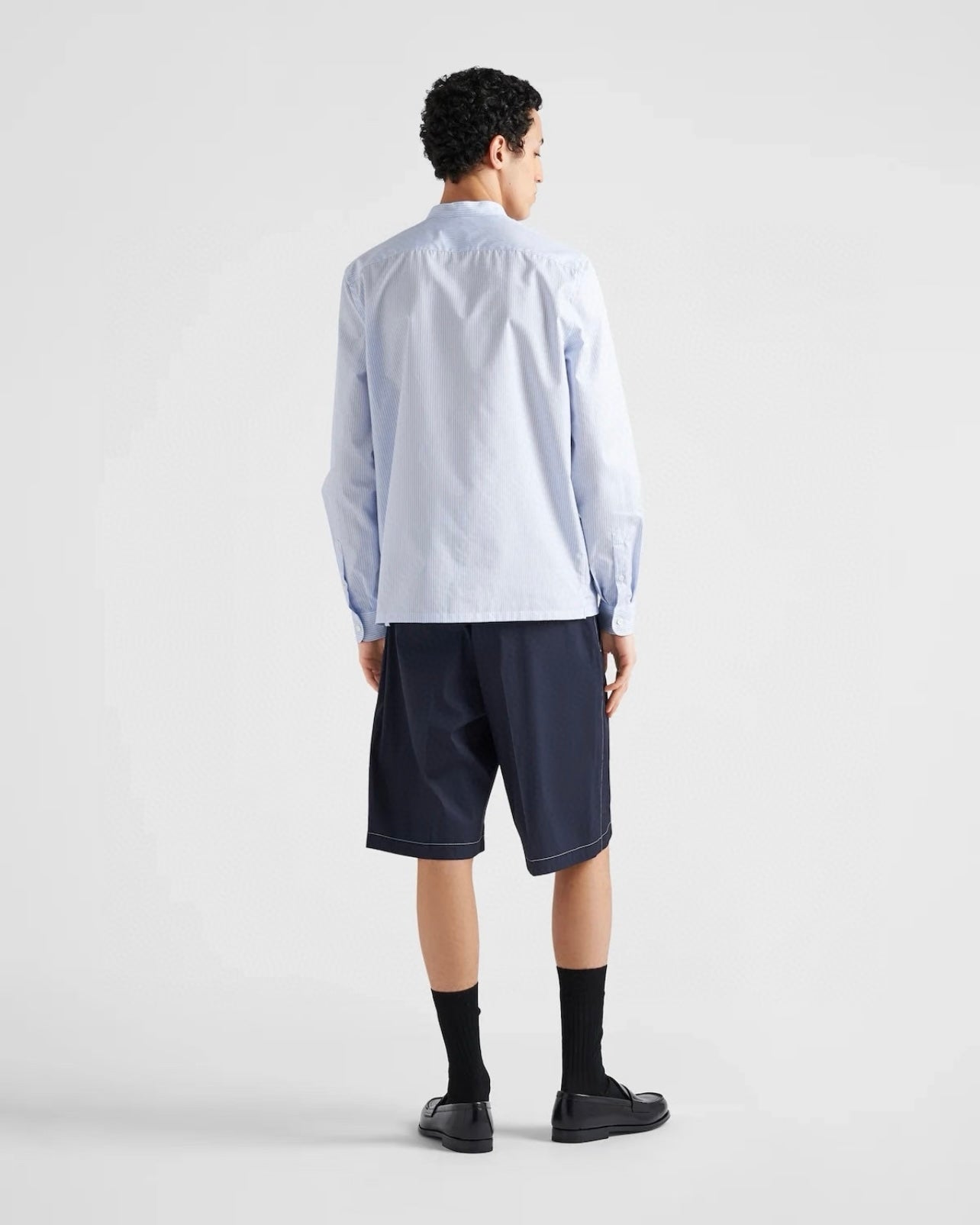 Navy Prada shorts from behind, knee-length hem and front-to-back seams