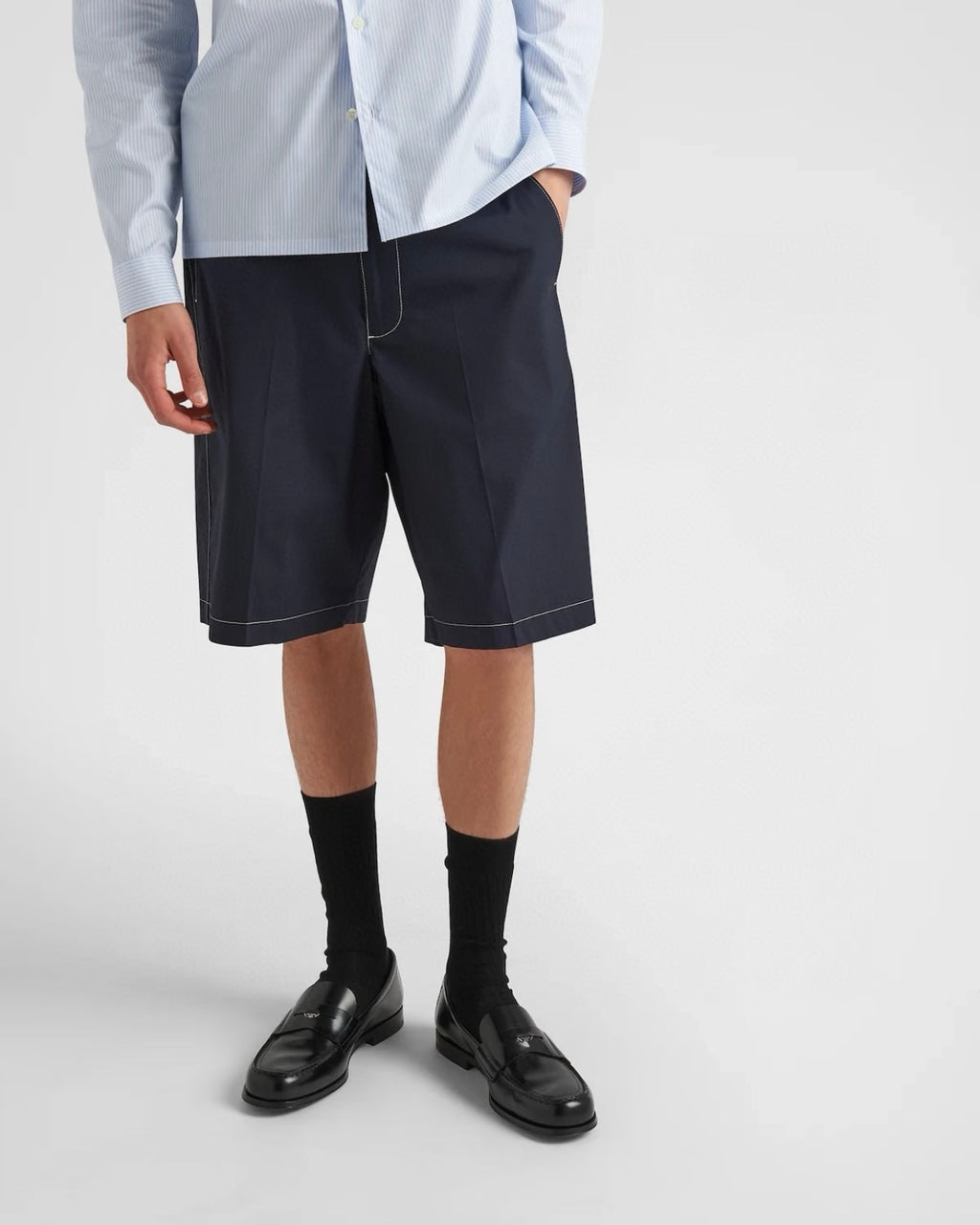 Navy Prada shorts on model, straight cut with stitched side panels