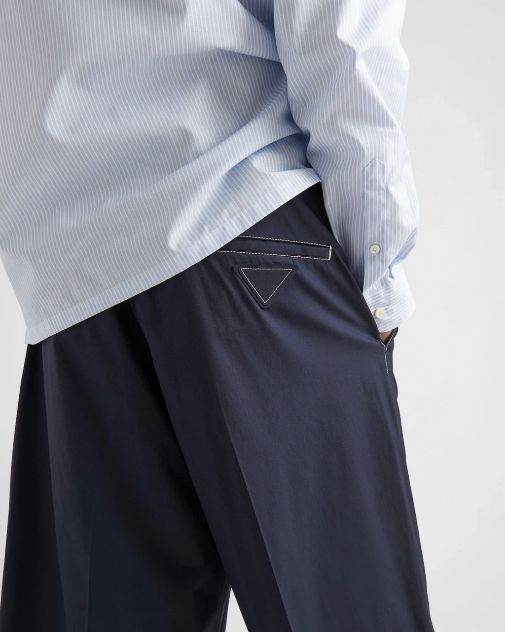 Navy Prada shorts close-up, triangular stitched logo on waistband