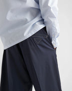 Navy Prada shorts close-up, triangular stitched logo on waistband