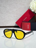 Prada glasses with black frames and yellow-tinted lenses