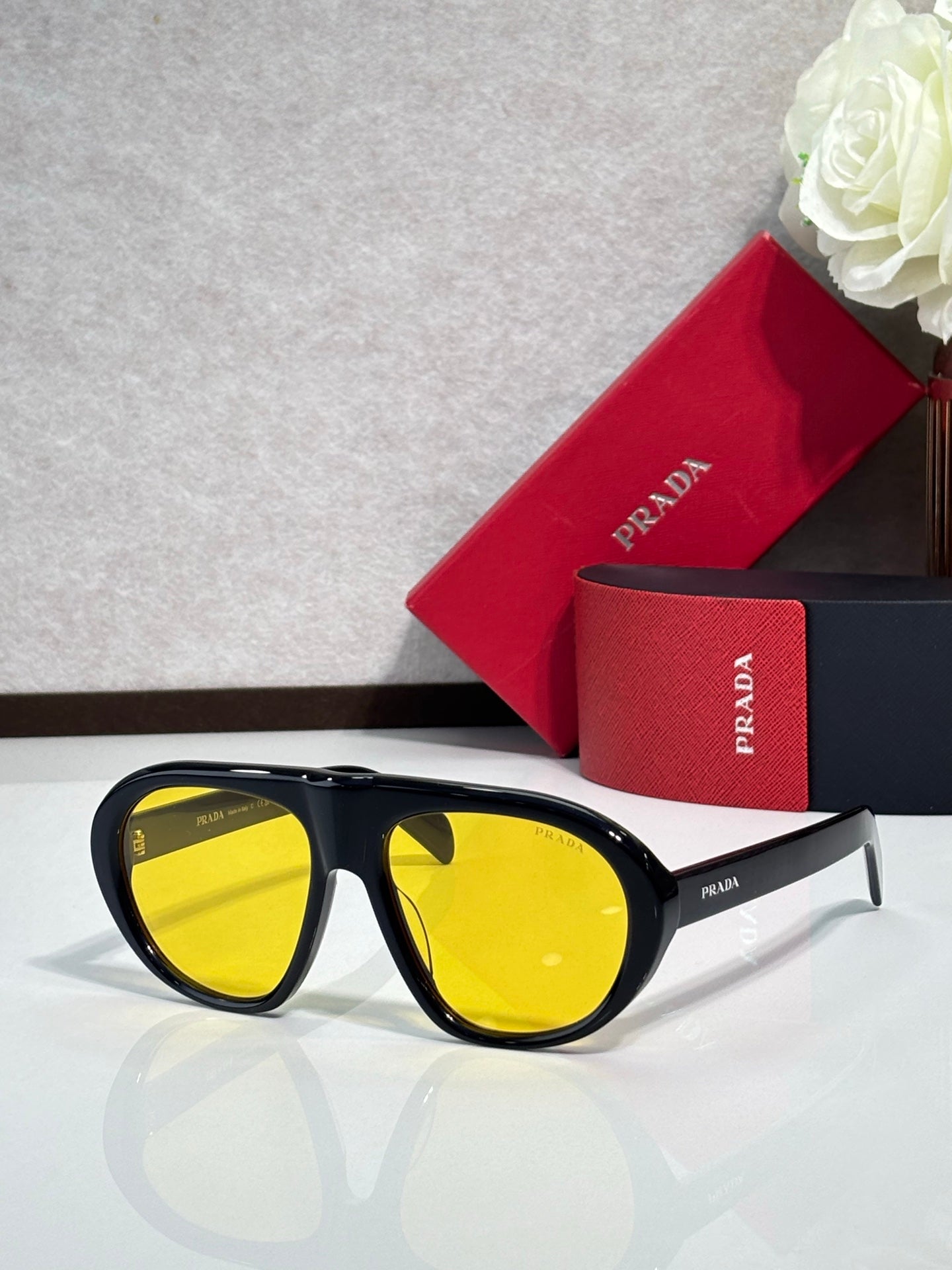 Prada glasses with black frames and yellow-tinted lenses