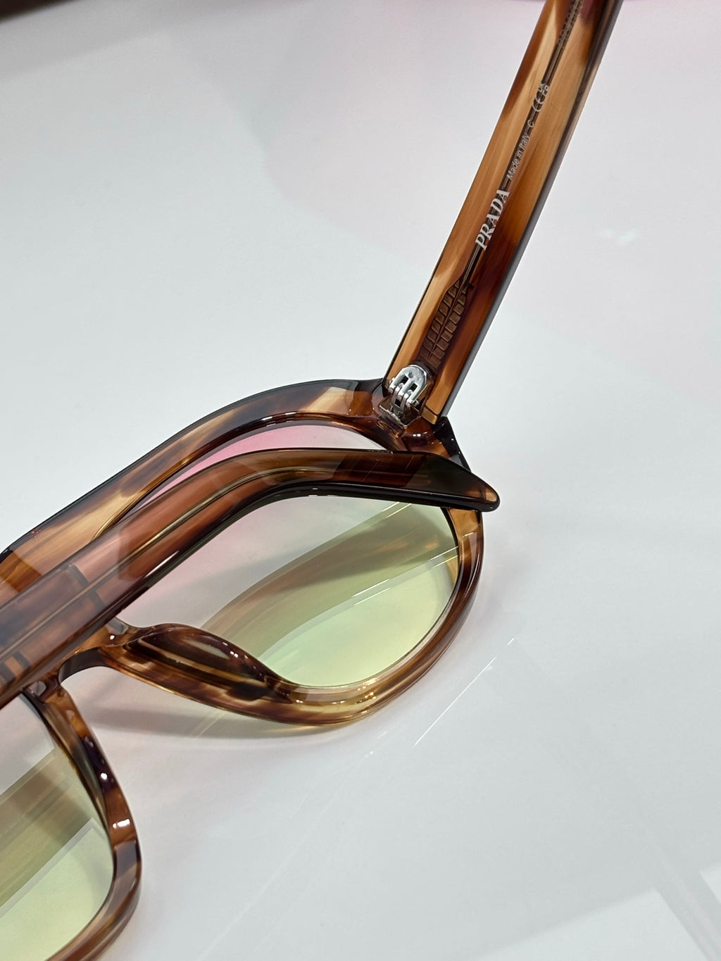 Prada glasses close-up of tortoiseshell temple and tinted lens
