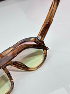 Prada glasses close-up of tortoiseshell temple and tinted lens