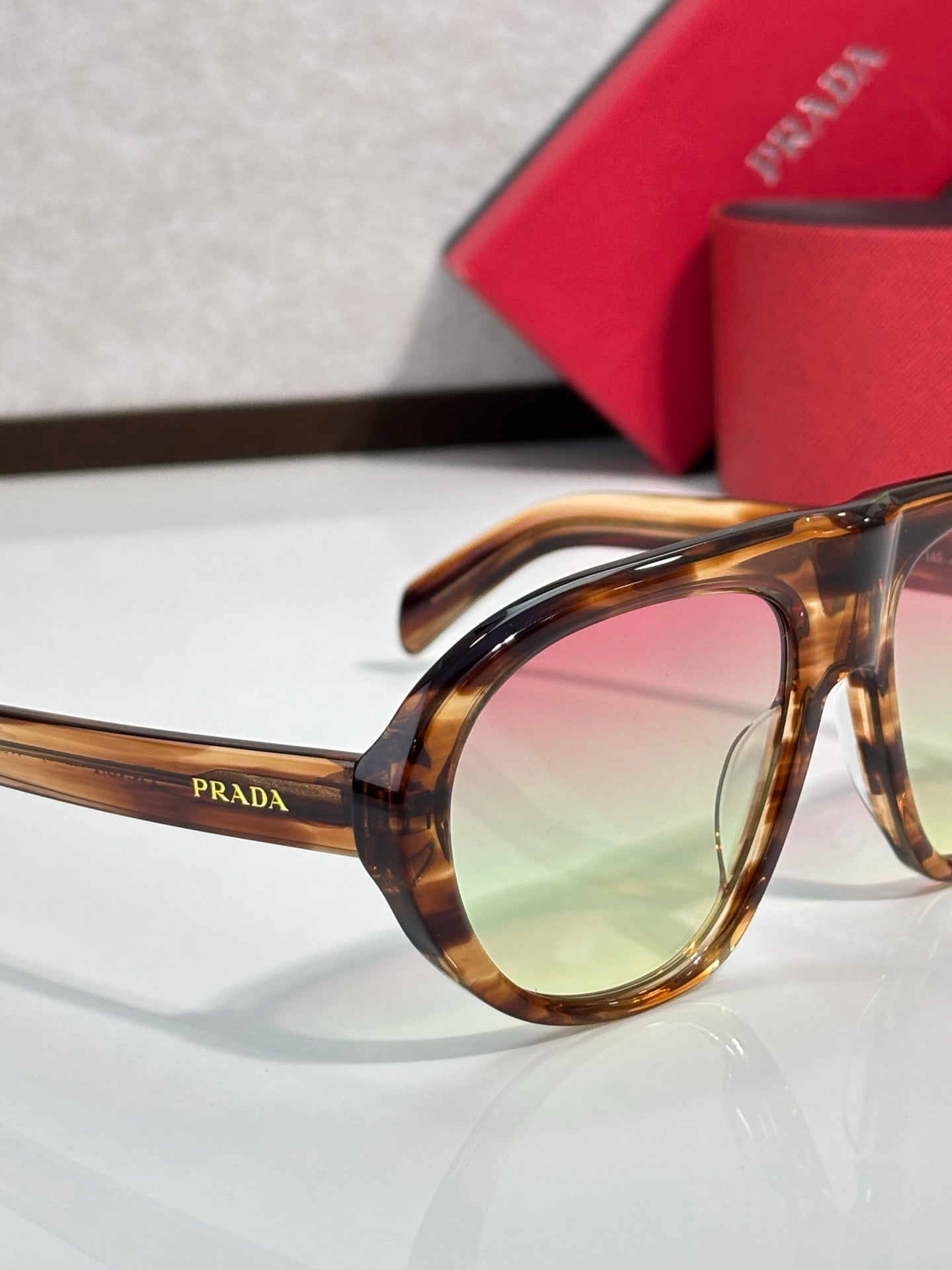 Prada glasses side profile with tortoiseshell frame and tinted lenses