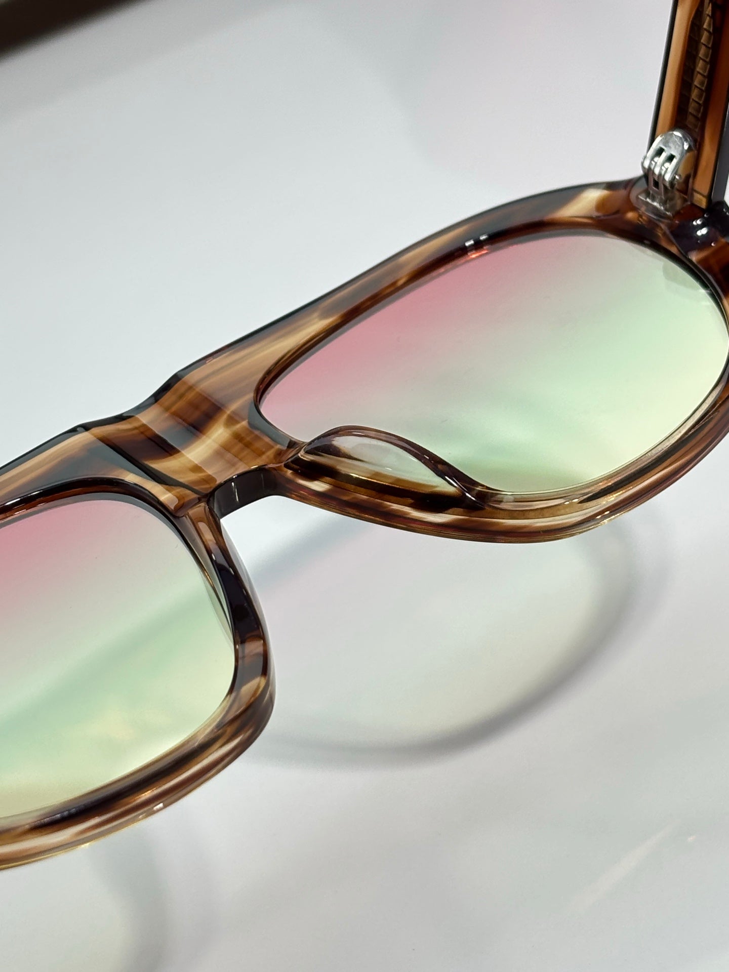 Prada glasses close-up of tortoiseshell frame edge and tinted lens