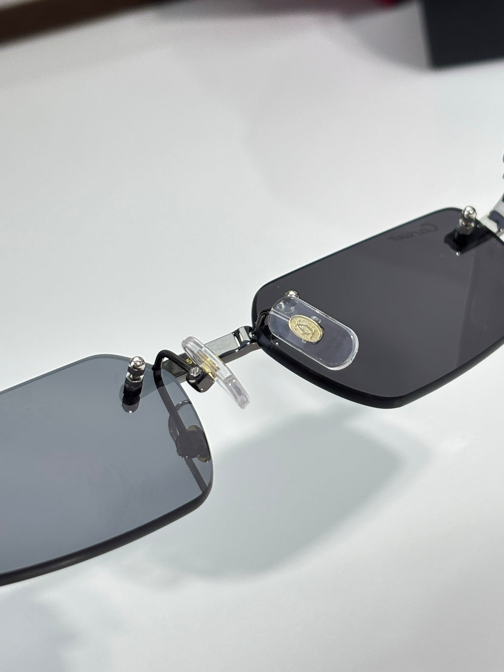Cartier sunglasses, close-up of black lenses and gold logo temple piece
