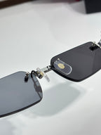 Cartier sunglasses, close-up of black lenses and gold logo temple piece