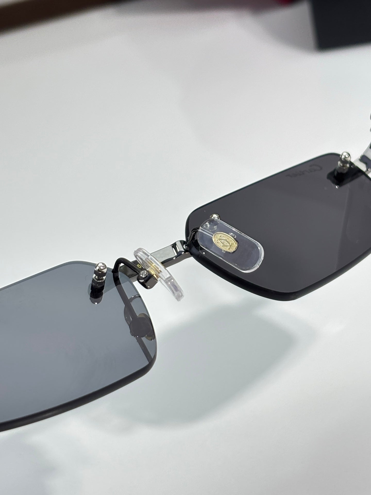 Cartier sunglasses, close-up of black lenses and gold logo temple piece