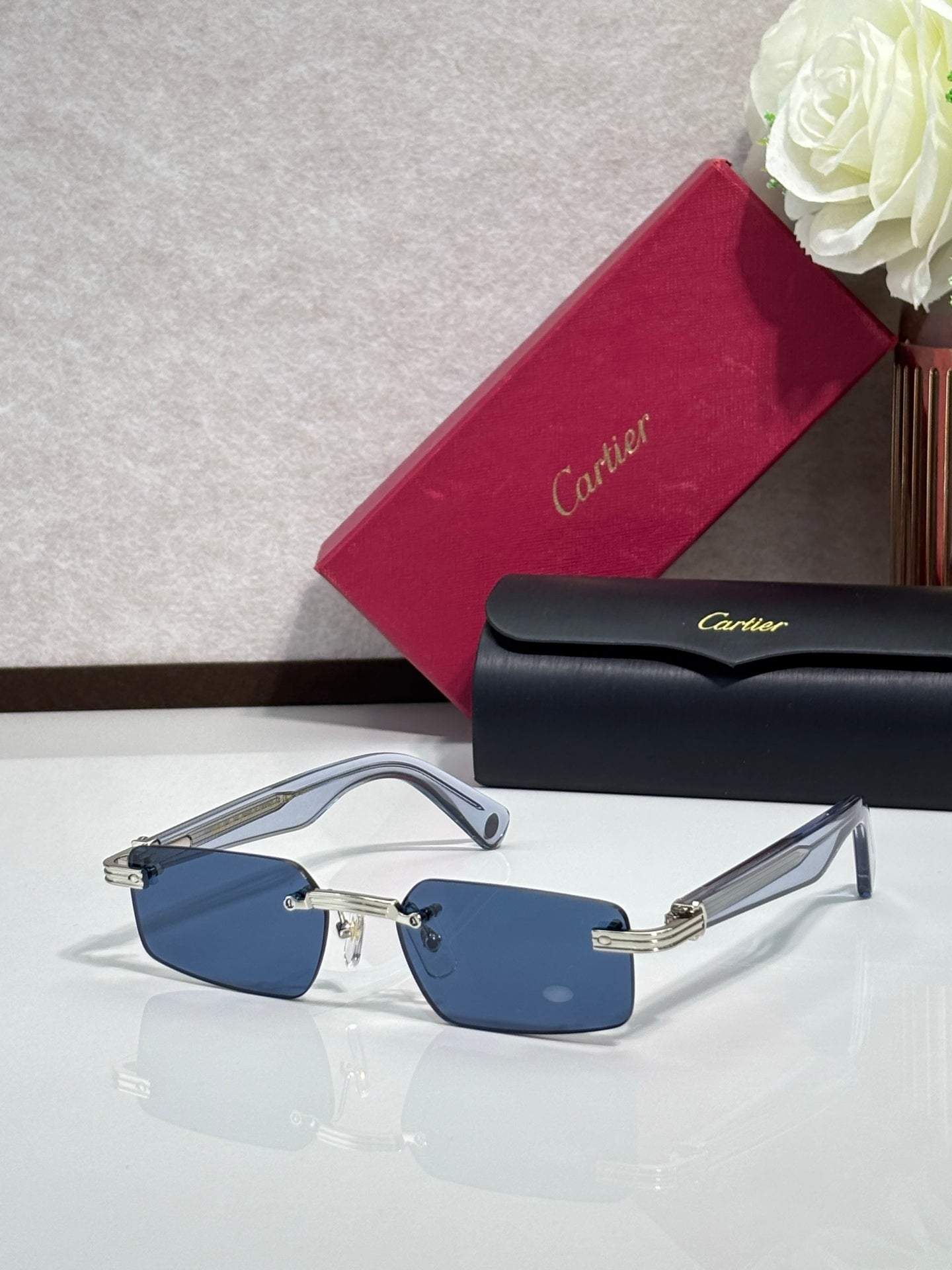 Cartier sunglasses with light blue lenses, silver-tone frame and gold hinges