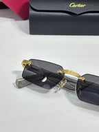 Cartier sunglasses in dark lenses with gold metal hinge and curved brow