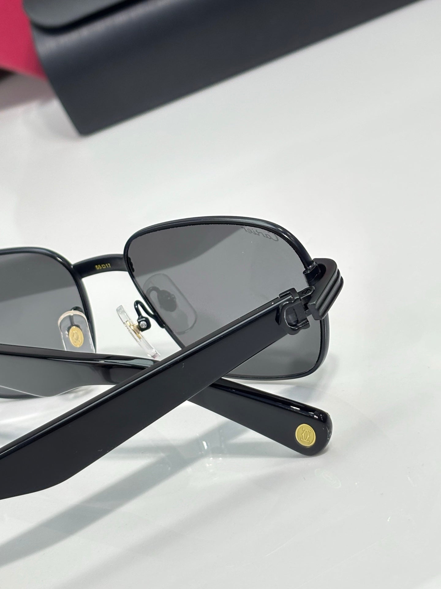 Cartier sunglasses side view with black frame and dark lenses, logo on temple