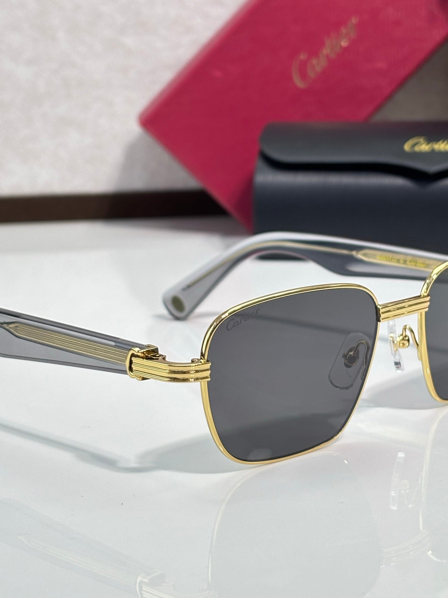 Cartier sunglasses close-up with gold frame and dark square lens