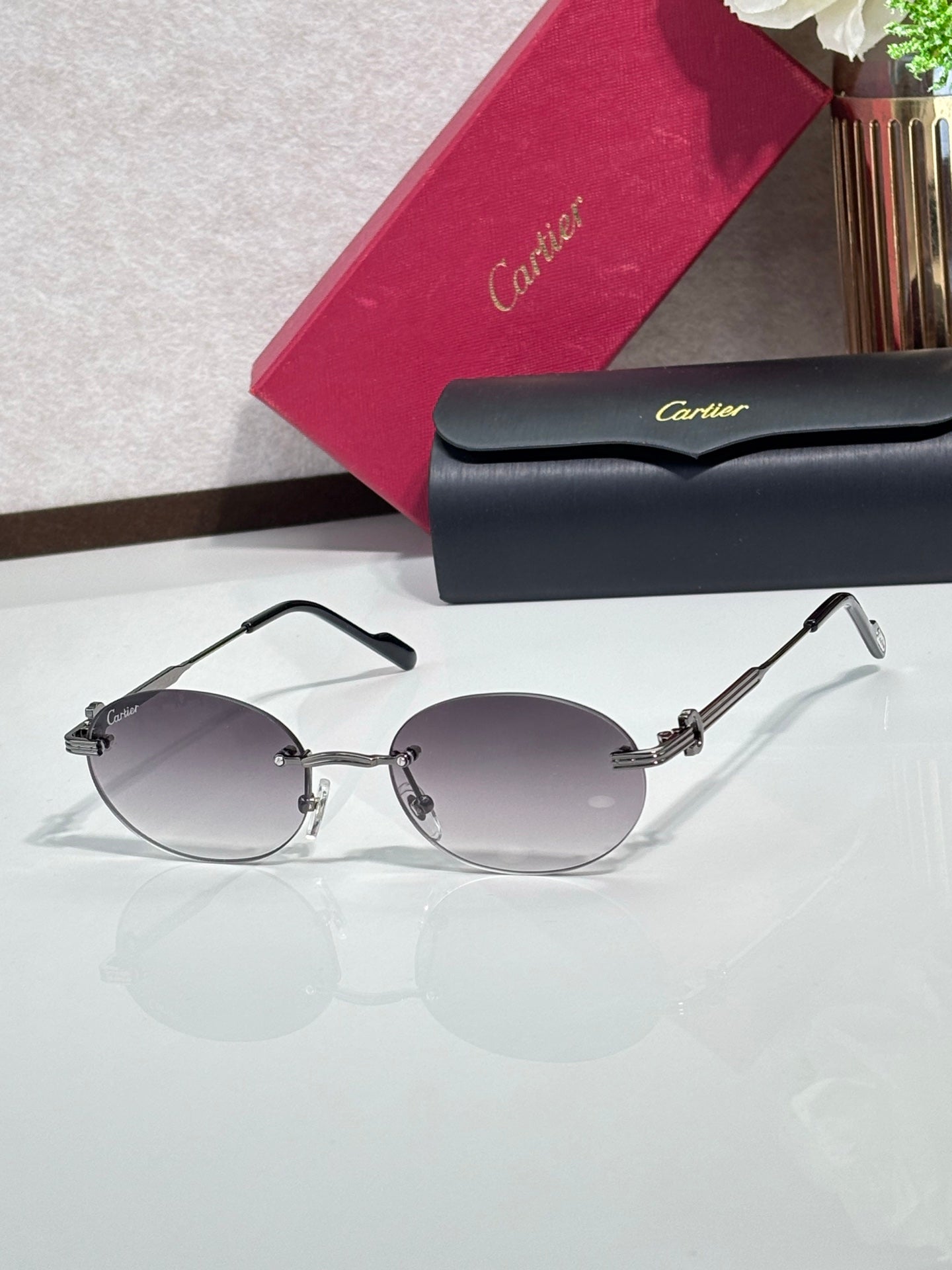 Round gray sunglasses with clear lenses, gold-tone metal frame, and short gold detailing