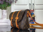 Louis Vuitton monogram bag with tan straps, side view and colorful accessory charm