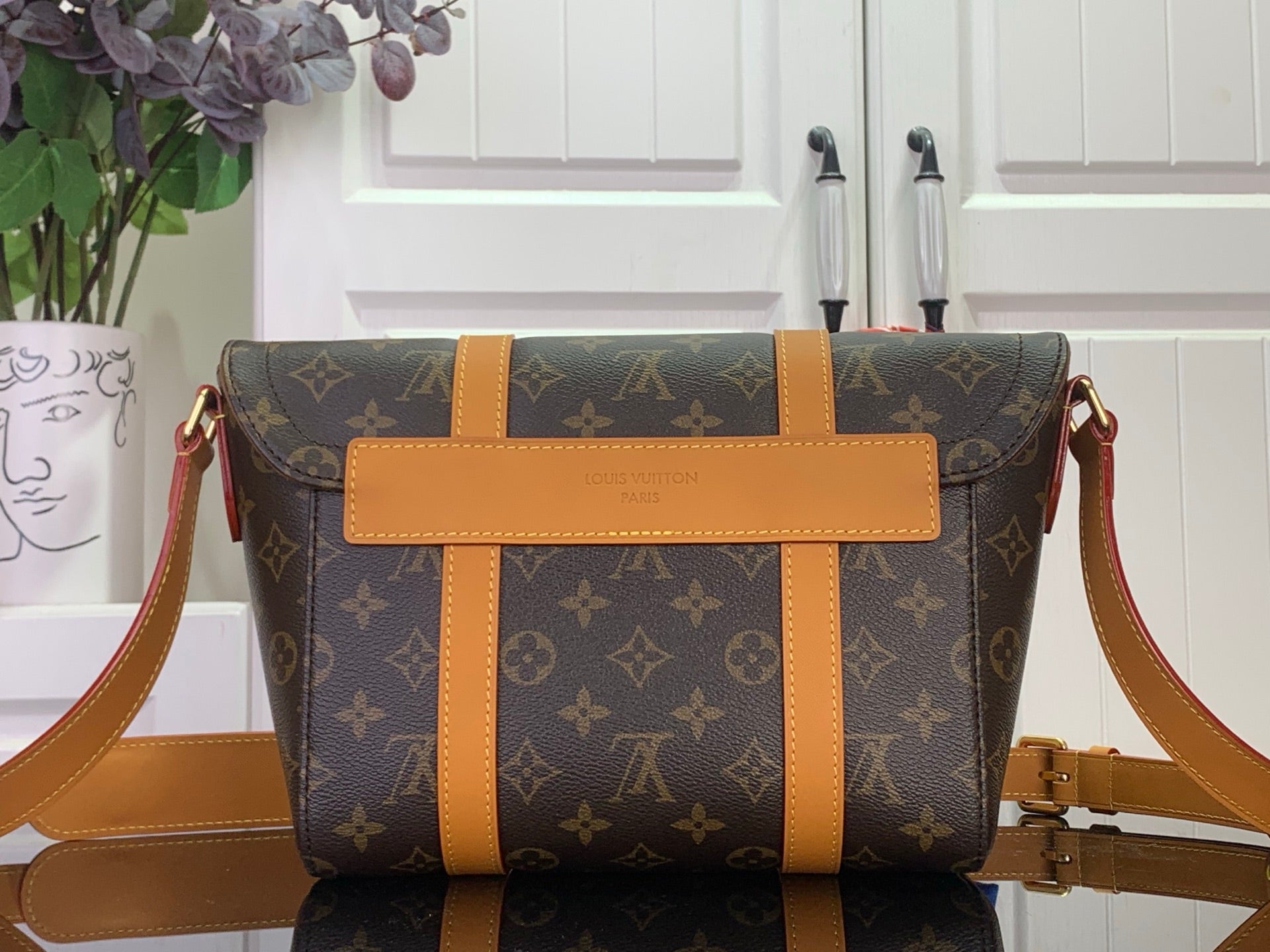 Louis Vuitton monogram bag with tan center strap and shoulder strap, front view