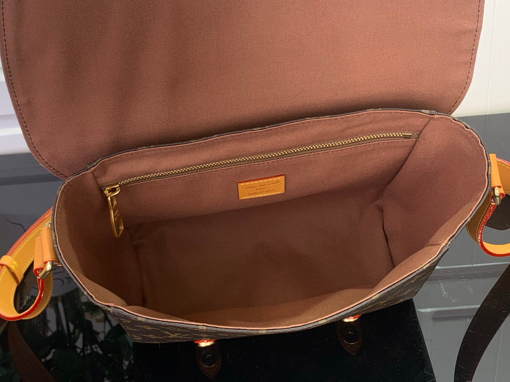Louis Vuitton bag interior with tan lining and zipper pocket, open top view