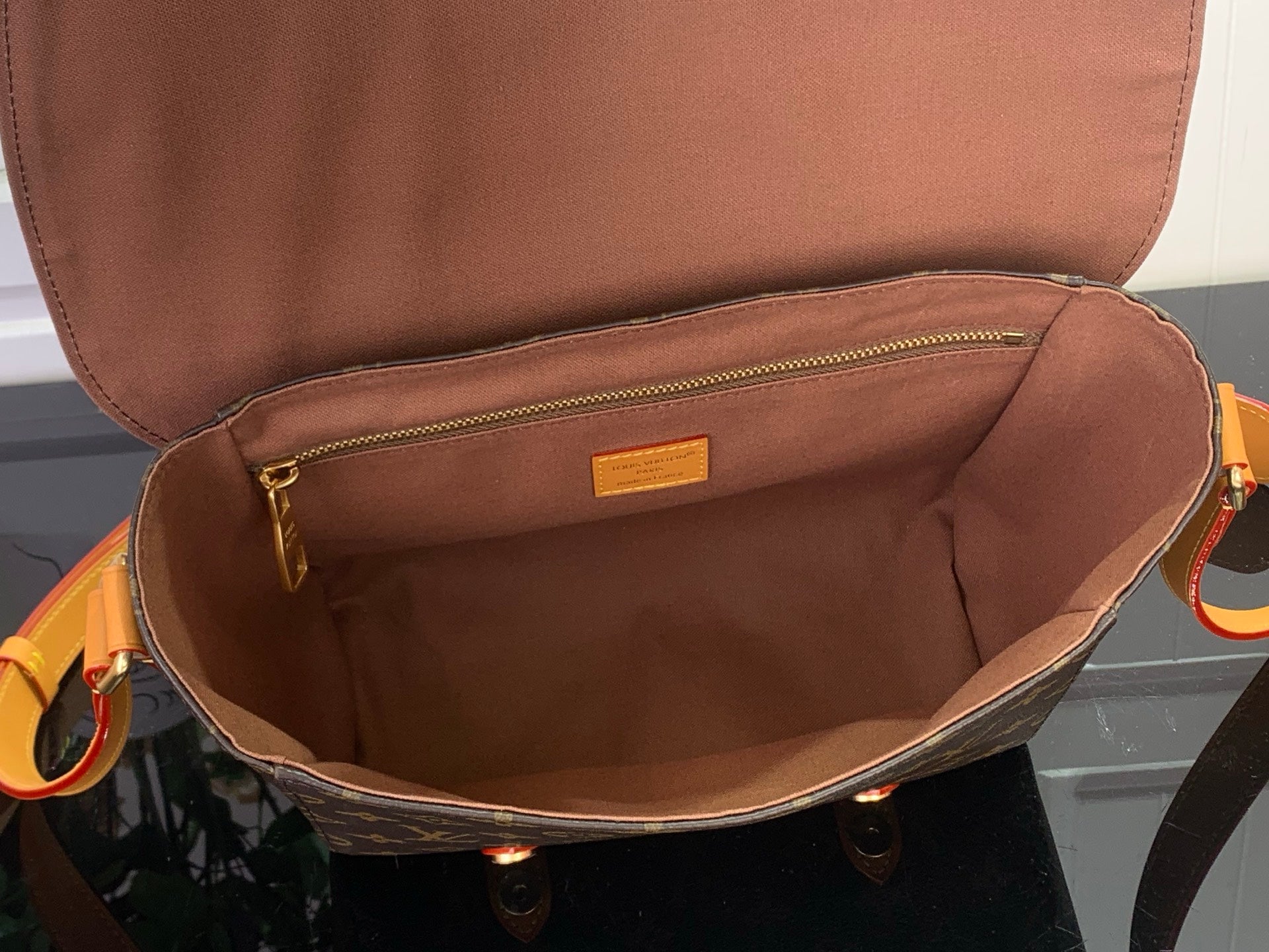 Louis Vuitton bag interior with tan lining and zipper pocket, open top view