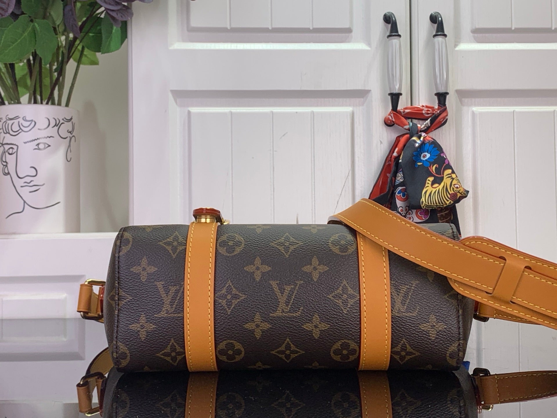 Louis Vuitton monogram bag with tan strap and foldover top, side profile