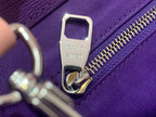 Silver zipper pull and Noé signature tag on purple bag