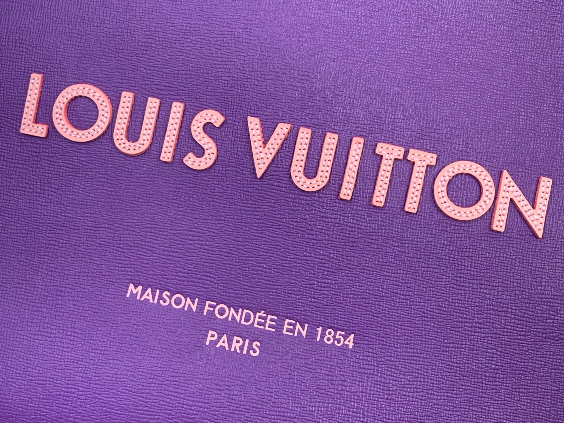 Purple bag logo close-up with Louis Vuitton lettering