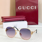 Round sunglasses with gold-tone frame and purple tinted lenses, slim metal arms.
