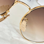 Gold-tone sunglasses temple with engraved logo plate and rhinestone details.