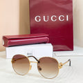 Round sunglasses with gold-tone frame and amber tinted lenses, thin metal arms.
