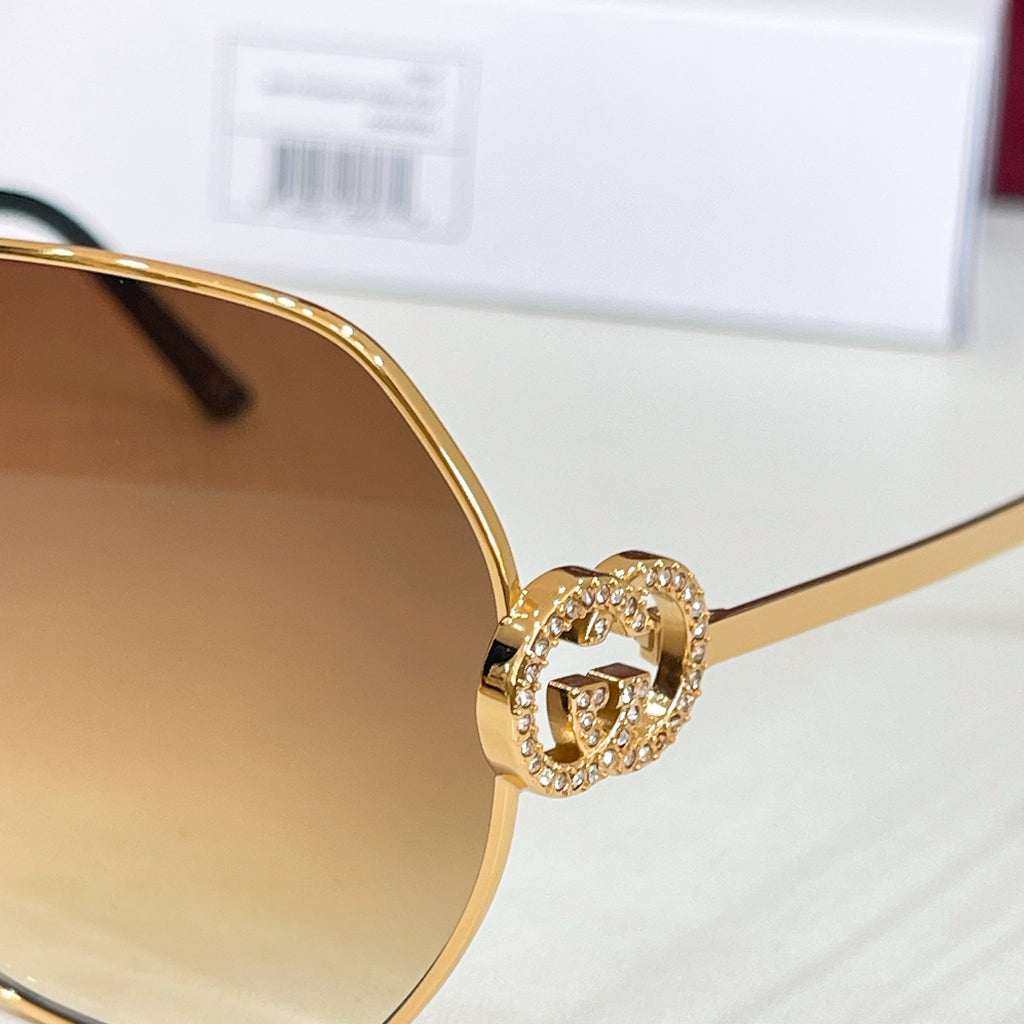Gold sunglasses hinge with pavé logo detail on the temple
