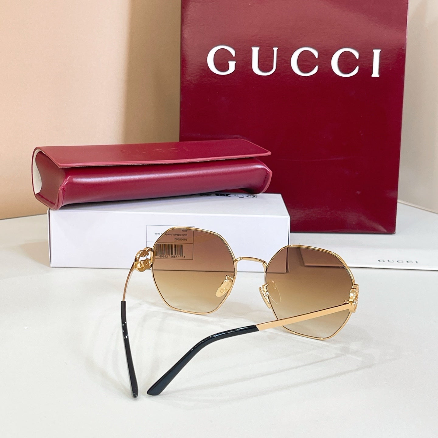Gold round sunglasses with amber tinted lenses and black temple arms