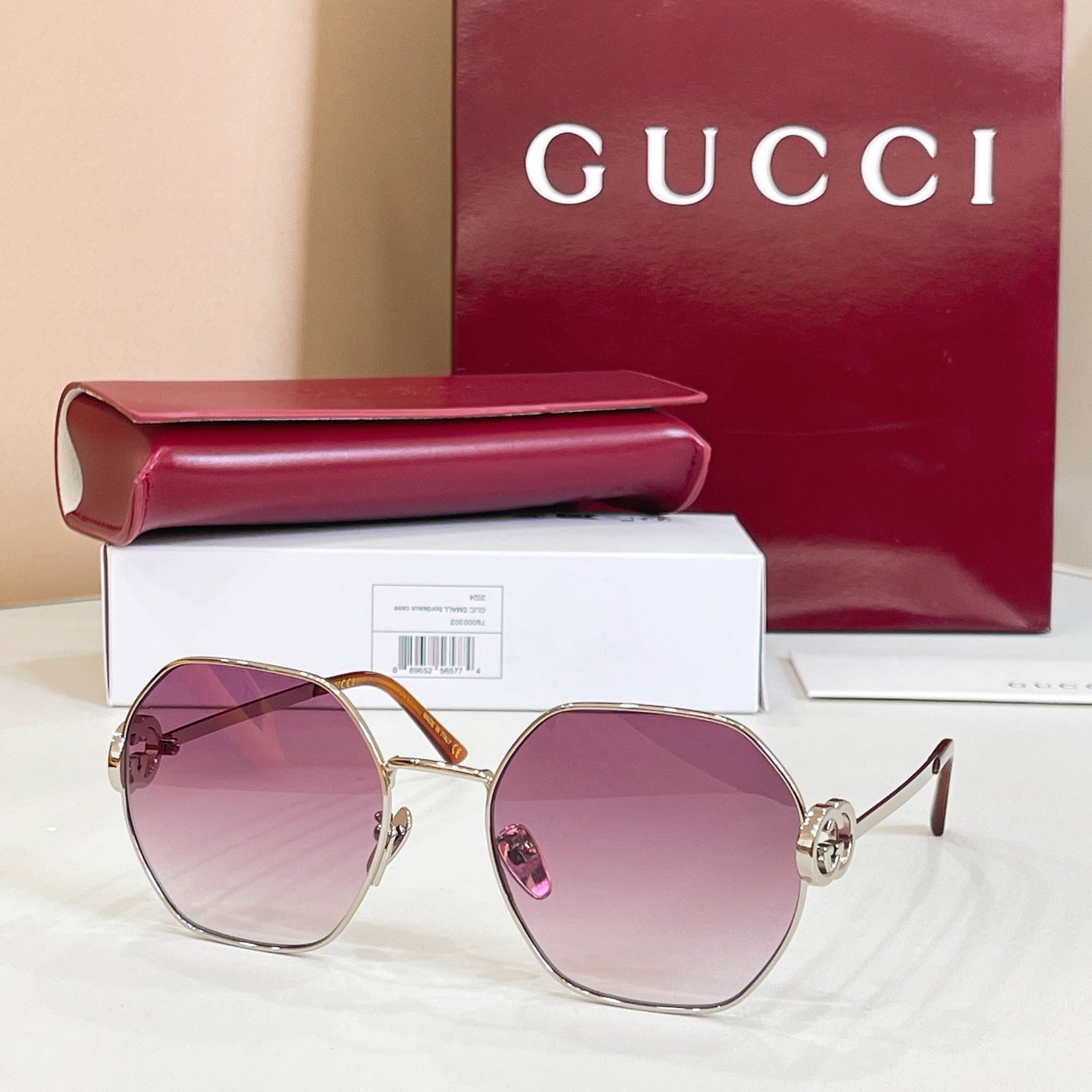 Gold round sunglasses with purple tinted lenses and black temple tips