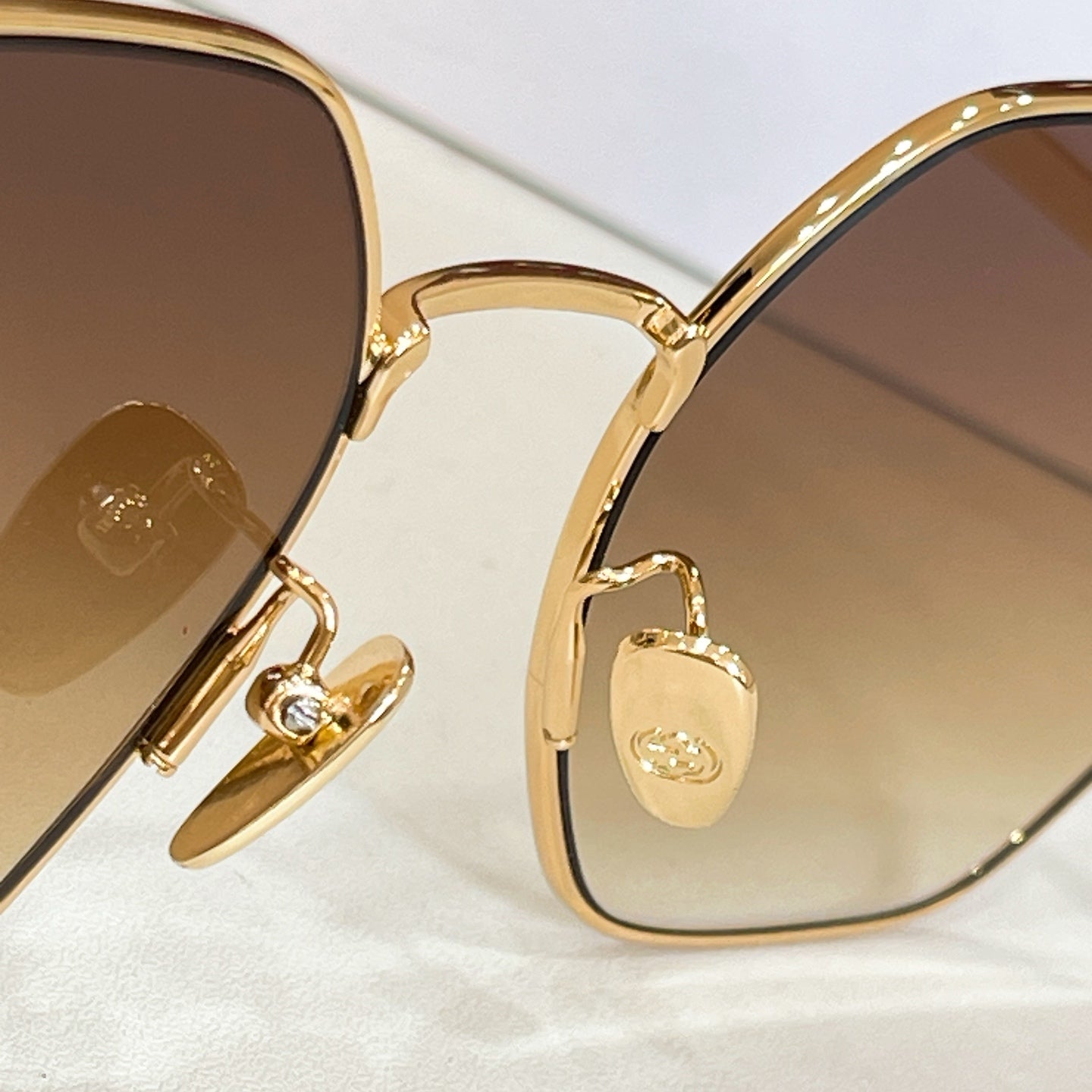 Gold sunglasses with hinged detail and amber tinted lenses