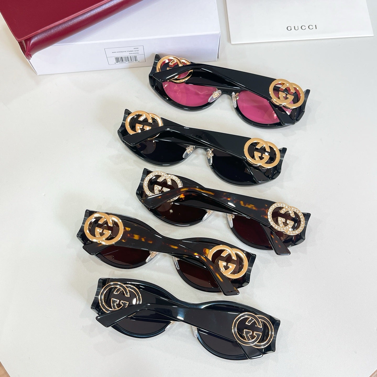 Set of Gucci sunglasses with black frames and GG logo temples, mixed lens colors