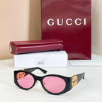 Gucci sunglasses with black frames and pink lenses, gold logo on temple