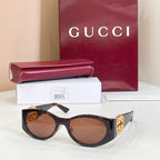 Gucci sunglasses with black frames and brown lenses, gold logo detail on temple