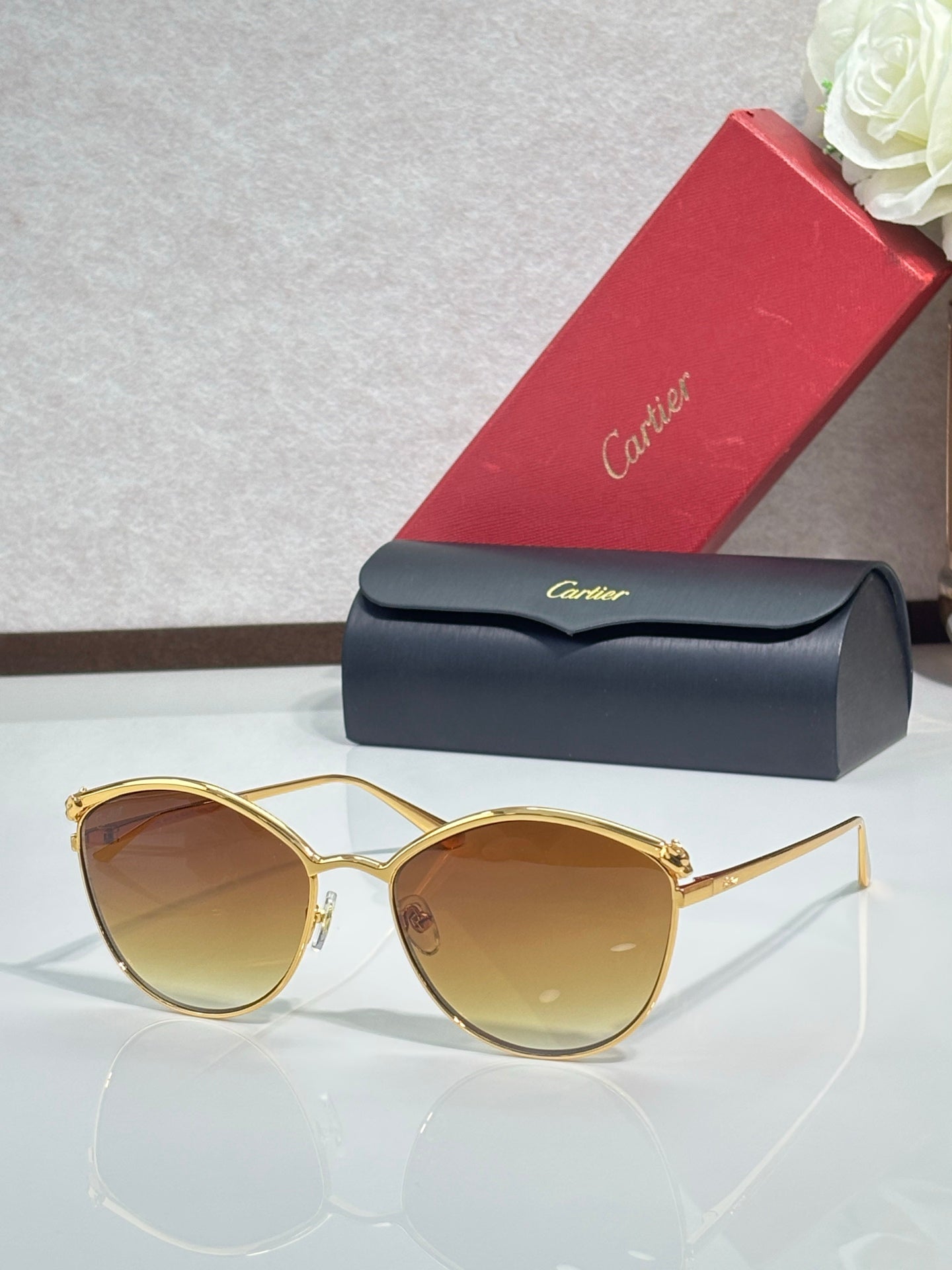 Gold round sunglasses with tinted brown lenses and thin metal frame, nose bridge detail.